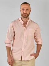 Camisa de lino color salmón de corte clásico, con cuello abotonado, manga larga con puños abotonados y bolsillo en el pecho.