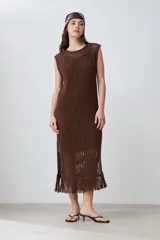 Vestido marrón de tejido calado, corte recto, largo midi, sin mangas y con flecos en el ruedo.