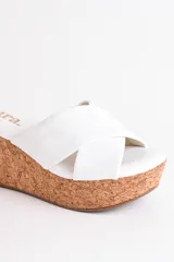 Sandalia dorada con plataforma de corcho, tiras cruzadas de cuero y plantilla acolchada.