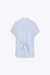 Camisa celeste de manga corta con cuello solapa y cierre frontal con botones. Tiene un nudo en la parte delantera.