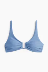 Top de bikini celeste con breteles ajustables, alambre de metal en forma de U en el busto y tiras para atar en la espalda. Copas con rellenos extraíbles que moldean el busto y proporcionan una buena sujeción. Sin aros. Forrado.