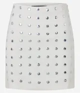 Pollera corta ajustada de bengalina color blanco, con tachuelas metálicas aplicadas en forma de puntos.