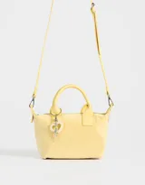 Cartera amarilla con doble asa corta de mano y correa regulable desmontable. Incluye charm colgante de perlas y cierre superior.