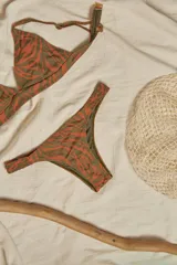 Bikini de triángulo con top fijo que incluye breteles regulables y almohadillas desmontables, y bottom vedetina con frunce elástico en los costados.