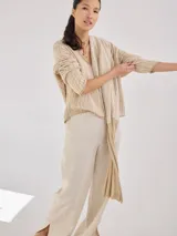 Chal color beige con diseño jacquard, de forma rectangular y caída fluida.