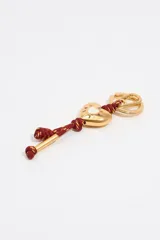 Llavero con dije de corazón dorado grabado con el logo de Bimba y Lola, unido a un cordón trenzado color bordó con nudos y herrajes dorados que incluyen un mosquetón y una anilla.