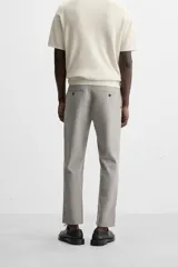 Pantalón de vestir gris oscuro, corte slim fit, con bolsillos laterales y traseros con botón.