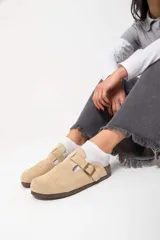 Mocasines negros de cuero con hebilla dorada y suela de corcho.