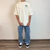Pantalón jean color beige, de corte holgado y estilo cargo, con múltiples bolsillos laterales.