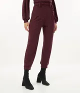 Pantalón jogger color borgoña confeccionado en malla flamê texturizada, con cintura con trabillas largos, cordón para amarre, pliegues delanteros y barra ajustada con pliegues.