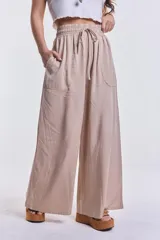Pantalón palazzo color beige de tencel con cintura elastizada y cordón ajustable.