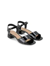 Sandalias negras de charol con pulsera al tobillo y hebilla dorada.