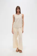 Blusa sin mangas con estampado a rayas verticales en tonos blanco, azul y verde. Presenta cuello redondo y lazos laterales.