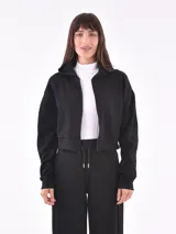 Campera corta negra con cierre frontal, cuello alto y puños elásticos.
