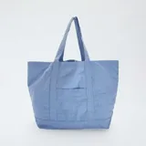 Bolso shopper de tela celeste con bolsillo frontal y asas de hombro.