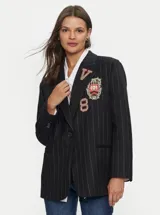 Blazer de un solo botón azul con rayas sutiles y parches decorativos en tonos azules, blanco y rojo.