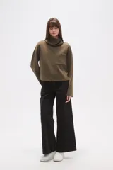 Buzo negro de manga larga con cuello alto tipo chimenea y un bolsillo cuadrado en el pecho.