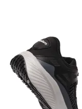 Championes Umbro modelo Adventure para hombre, color negro con detalles en gris oscuro. Presentan una capellada de malla transpirable con refuerzos sintéticos y la marca Umbro en relieve sobre el lateral. La suela es gruesa, de color gris claro, con una base negra.