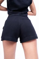 Short de tiro alto color beige, con pinzas delanteras, bolsillos laterales y cierre frontal con botón.