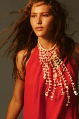 Vestido midi de color rojo con cuello halter ajustable mediante lazada y espalda descubierta. Presenta un diseño fluido y holgado confeccionado en mezcla de lino.