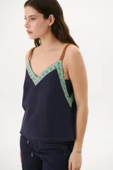 Musculosa color azul con breteles finos de cuero marrón y escote en V.