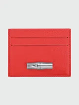 Tarjetero de cuero texturizado color rojo vibrante, con tres ranuras frontales para tarjetas y un cierre metálico decorativo con forma de bambú en tono plateado.