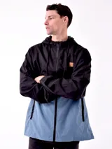 Campera con capucha azul marino y beige con cierre frontal y logo en el pecho.