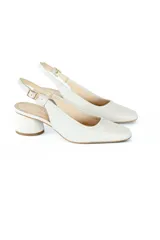Zapato de tacón color blanco con textura de piel de serpiente, talón descubierto y tira trasera con hebilla.