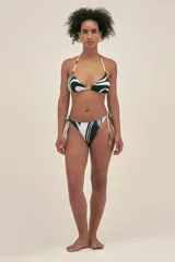 Bombacha de bikini colaless con estampado de mármol en tonos blanco y negro. Presenta tiras ajustables a los laterales con terminaciones insignia de la marca.