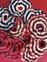 Gomita de pelo tejida al crochet con hilo de algodón a rayas en tonos rosa y violeta, con borde gris.