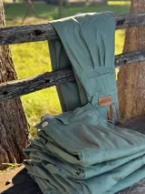 Pantalón de gabardina elastizada color verde seco, con bolsillos laterales y traseros.