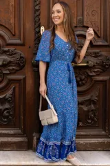 Vestido largo azul con estampado floral, escote en V, botones en el frente y volado en el ruedo.