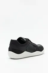 Zapatillas de cuero color blanco y beige, de diseño minimalista con suela marrón.