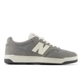 Championes New Balance modelo 480, color gris con detalles en blanco crema. Presentan una silueta de corte bajo, combinando gamuza y malla en el upper, con el logo 'N' en blanco crema y suela de goma bicolor.