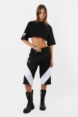 Remera corta negra de calce oversize confeccionada en jersey de algodón. Cuello de ribb ancho, ruedo al corte y estampa en la manga derecha.