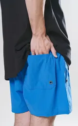 Short de baño azul con calce regular, cuatro bolsillos, elástico en la cintura y cordón para ajustar.