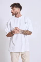 Remera blanca de corte holgado con pequeño estampado en el pecho.
