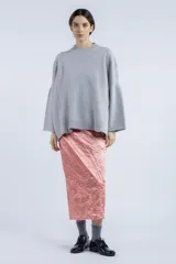 Sweater gris de punto con cuello redondo, mangas amplias y terminaciones acanaladas.