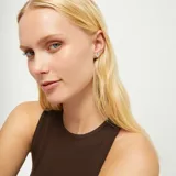 Par de aros tipo botón con forma de corazón tridimensional, acabado pulido y brillante, bañados en plata de ley.