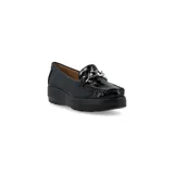 Mocasín de cuero charol negro con plataforma blanca y detalle de hebilla metálica plateada en el empeine.