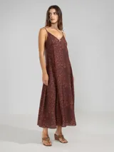 Vestido largo hasta el tobillo de viscosa y poliamida, con estampado de rayas verticales rosas y flores rojas. Tiene breteles finos, escote en V profundo y detalle de flor Polonio en cobre.