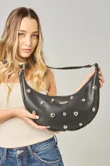 Cartera tipo bandolera de cuero sintético color celeste, con forma de media luna y tachas metálicas redondas plateadas en el frente. Posee correa ajustable y placa metálica con logo en la parte superior.