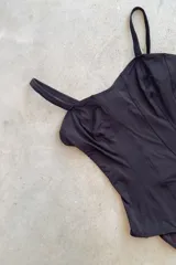 Malla enteriza negra entallada con ganchito en la espalda para cerrar. Espalda descubierta y bottom ancho.