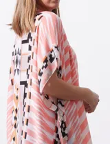 Kimono tejido con estampado abstracto en tonos beige, blanco y negro. Tiene mangas amplias estilo japonés y terminación de ruedo con borlas.