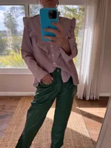 Pantalón slouchy de cuero ovino color verde inglés, corte mom fit con tiro semi alto y tajos inferiores.