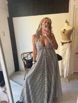 Vestido largo estampado animal print, con escote pronunciado en V y tirantes finos. La falda es amplia y fluida.