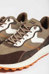 Zapatillas deportivas color beige con detalles en marrón y amarillo.