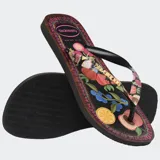 Ojotas Havaianas Top Tropicalia Vibes II, color negro con estampado de frutas tropicales y borde con patrón étnico. Las tiras son negras con el logo de Havaianas en dorado.