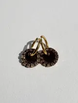 Par de aros dorados con dije circular de resina color terracota con glitter y borde de strass.