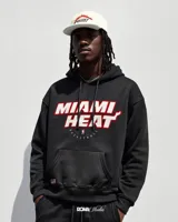 Canguro negro con capucha, puños y cintura acanalados. Estampado frontal con el nombre del equipo de baloncesto Miami Heat en blanco y rojo, y el logo de la NBA.